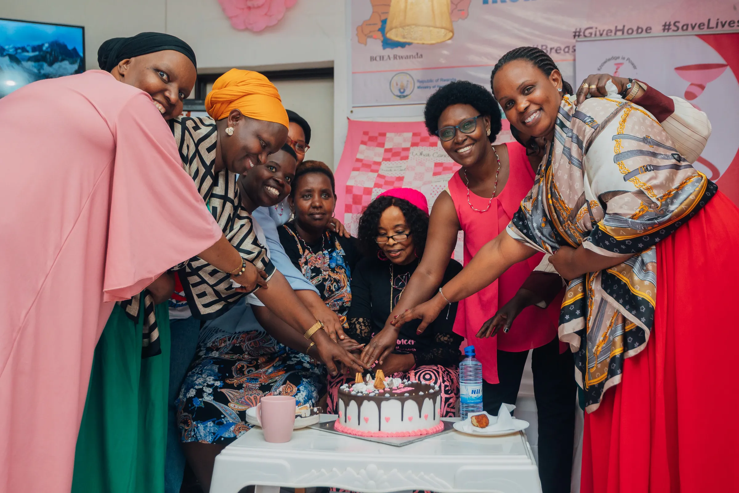 Women gathered together around a celebration cake in supplied BCIEA campaign photography